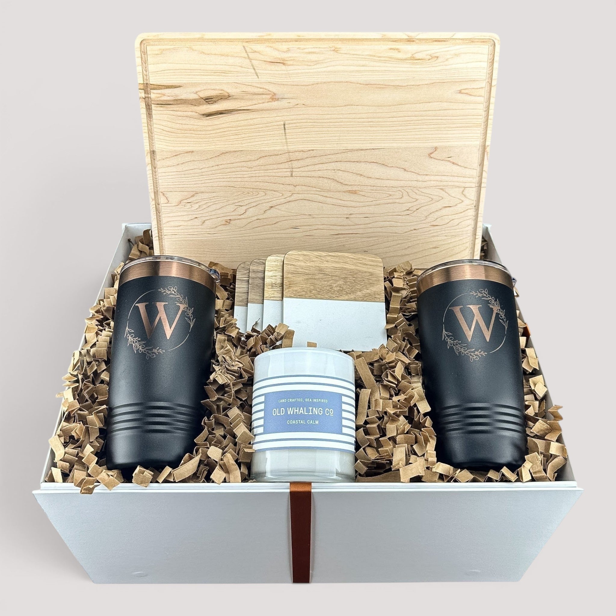 Closing Day Gifts personalized maple cutting board, black tumblers, marble coasters, and candle in a keepsake box.