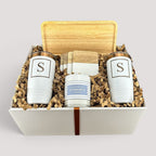Closing Day Gifts personalized rubber wood valet tray, engraved tumblers, maple coasters, and candle in a gift box.