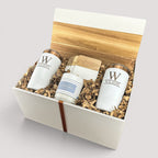 Closing Day Gifts personalized housewarming set featuring engraved white tumblers, coasters, and a candle in a box.