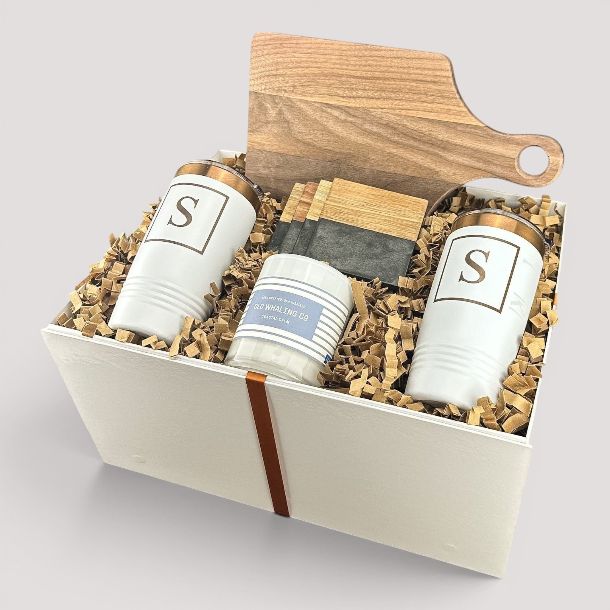 Closing Day Gifts personalized housewarming set with walnut cutting board, white tumblers, coasters, and scented candle.