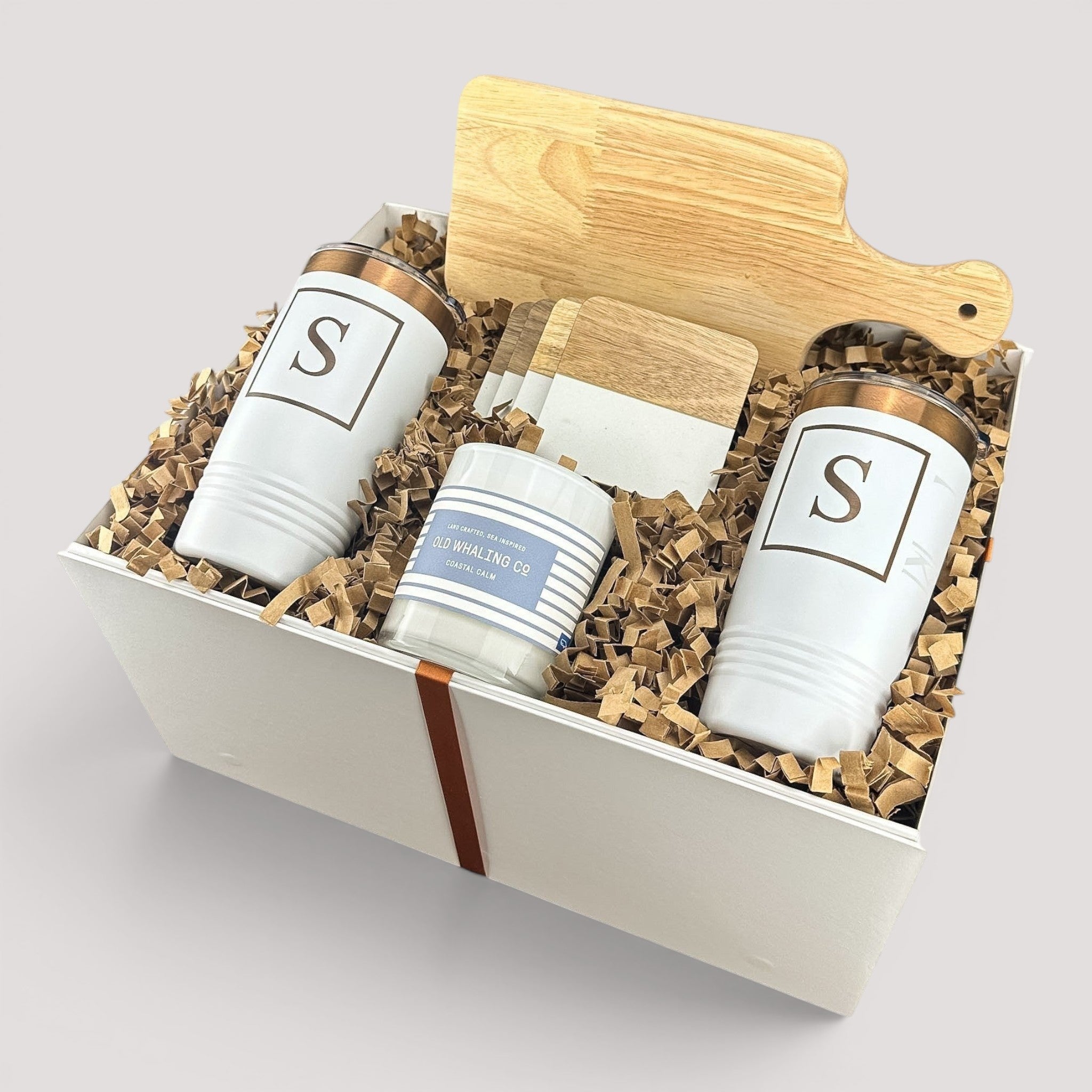 Closing Day Gifts personalized housewarming set with rubber wood cutting board, two white tumblers, coasters, and candle.