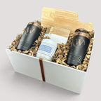 Closing Day Gifts personalized housewarming set with rubber wood cutting board, two black tumblers, and coasters.