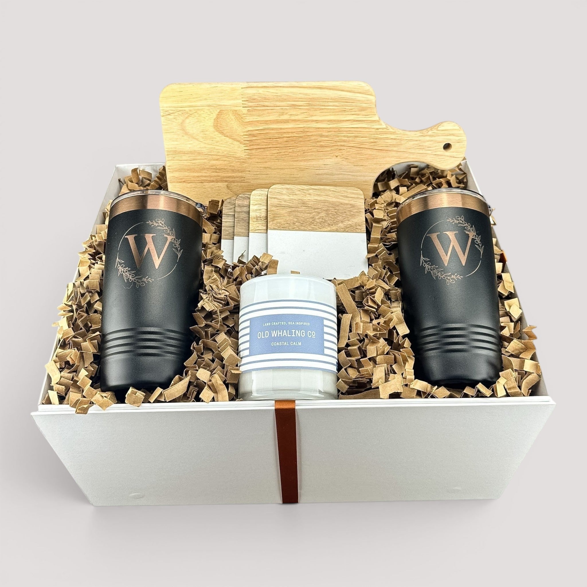 Closing Day Gifts personalized housewarming set with rubber wood cutting board, black tumblers, coasters, and candle.