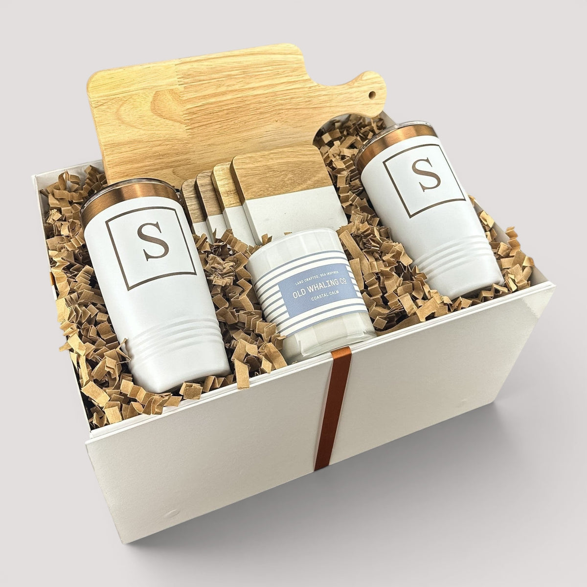 Closing Day Gifts personalized housewarming set with rubber wood cutting board, two white tumblers, coasters, and candle.