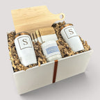 Closing Day Gifts personalized housewarming set with maple cutting board, white tumblers, marble coasters, and candle.