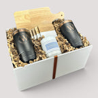 Closing Day Gifts personalized housewarming set with rubber wood cutting board, black tumblers, coasters, and candle.
