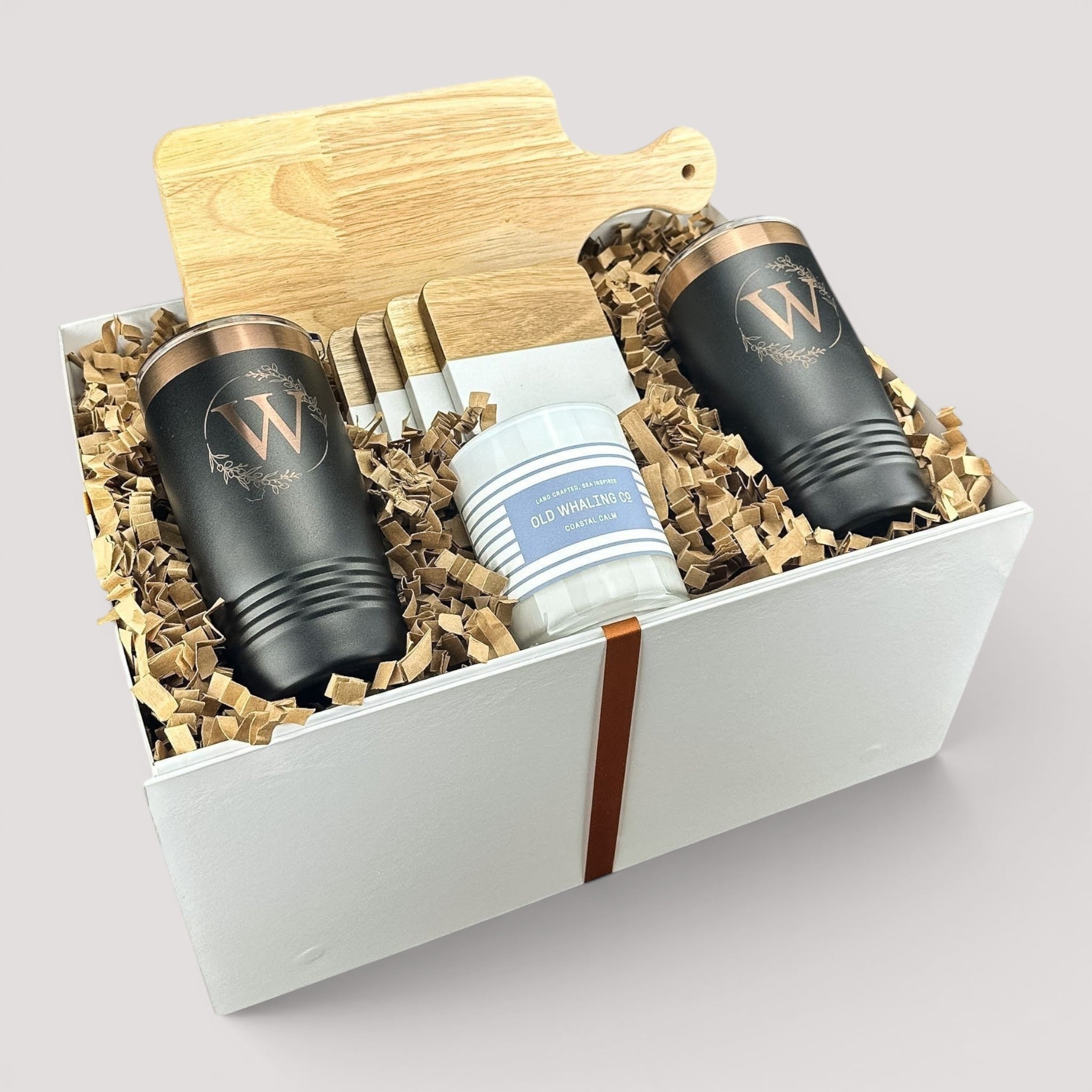Closing Day Gifts personalized housewarming set with rubber wood cutting board, black tumblers, coasters, and candle.