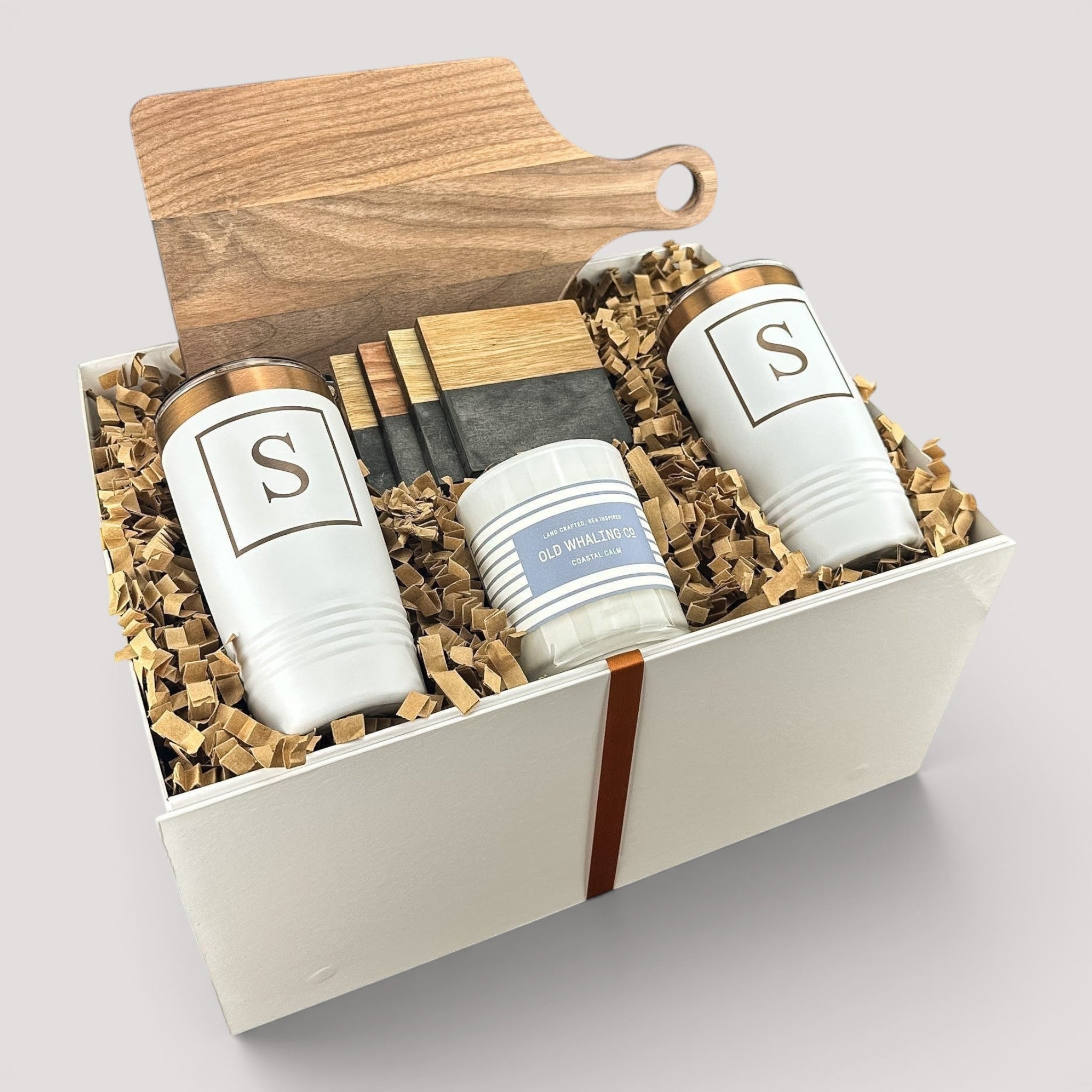 Closing Day Gifts personalized housewarming set with walnut cutting board, white tumblers, marble coasters, and candle.