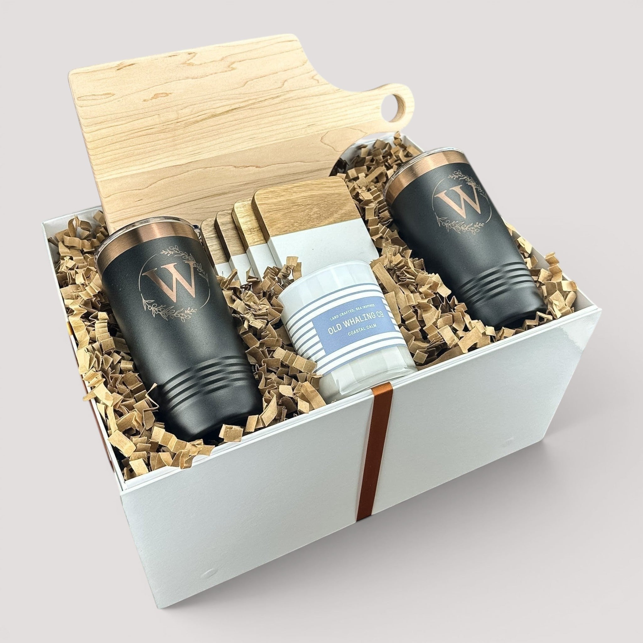 Closing Day Gifts personalized housewarming set with maple cutting board, black tumblers, marble coasters, and candle.
