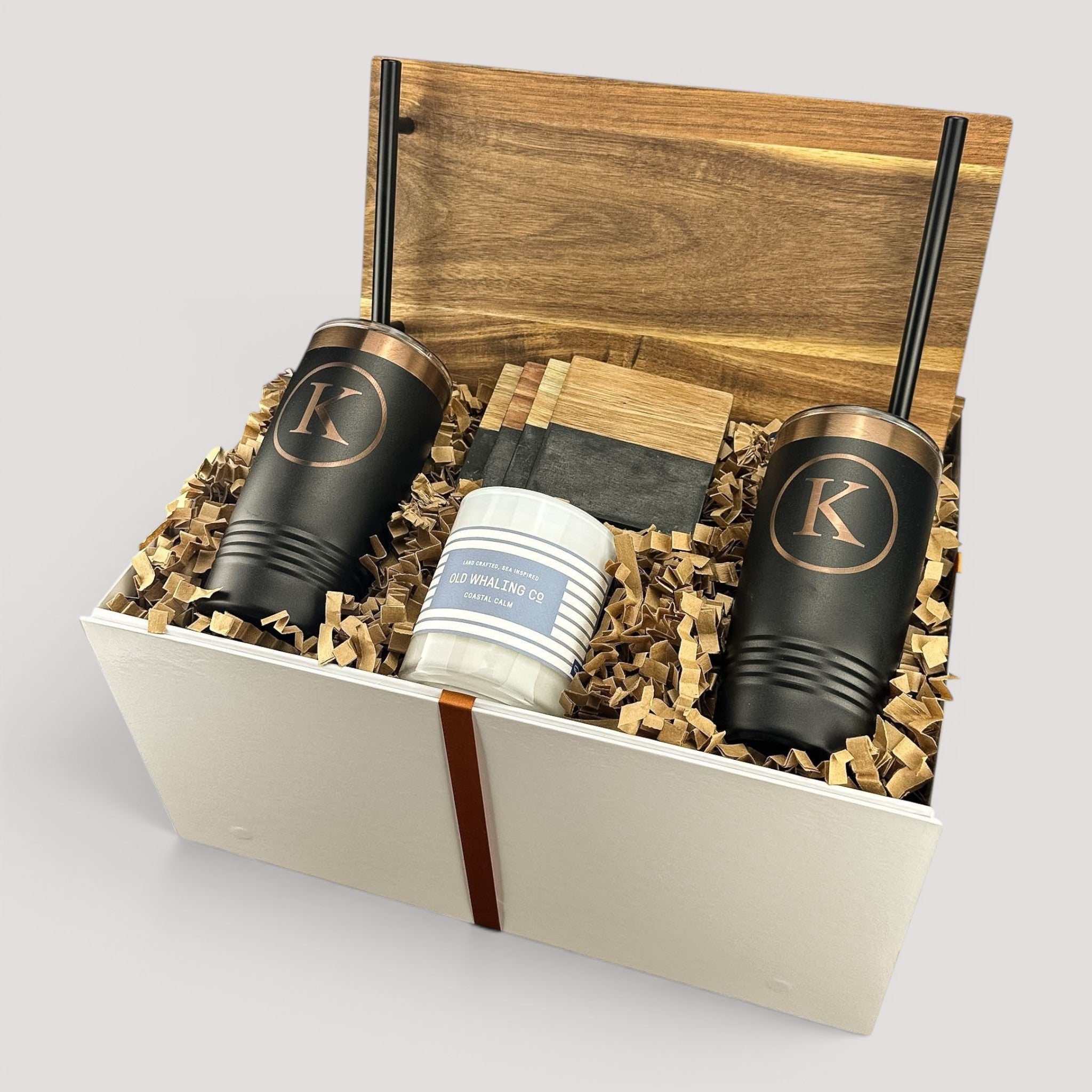 Closing Day Gifts personalized housewarming set featuring engraved black tumblers, marble coasters, and a scented candle.