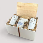 Closing Day Gifts personalized maple cutting board, engraved tumblers, marble coasters, and candle in a gift box.