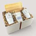 Closing Day Gifts personalized rubber wood valet tray, white tumblers, maple coasters, and candle in a gift box.