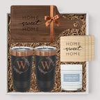 Closing Day Gifts personalized walnut cutting board, engraved tumblers, marble coasters, and candle in a gift box.