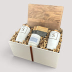 Closing Day Gifts personalized walnut cutting board, engraved tumblers, marble coasters, and candle in a gift box.