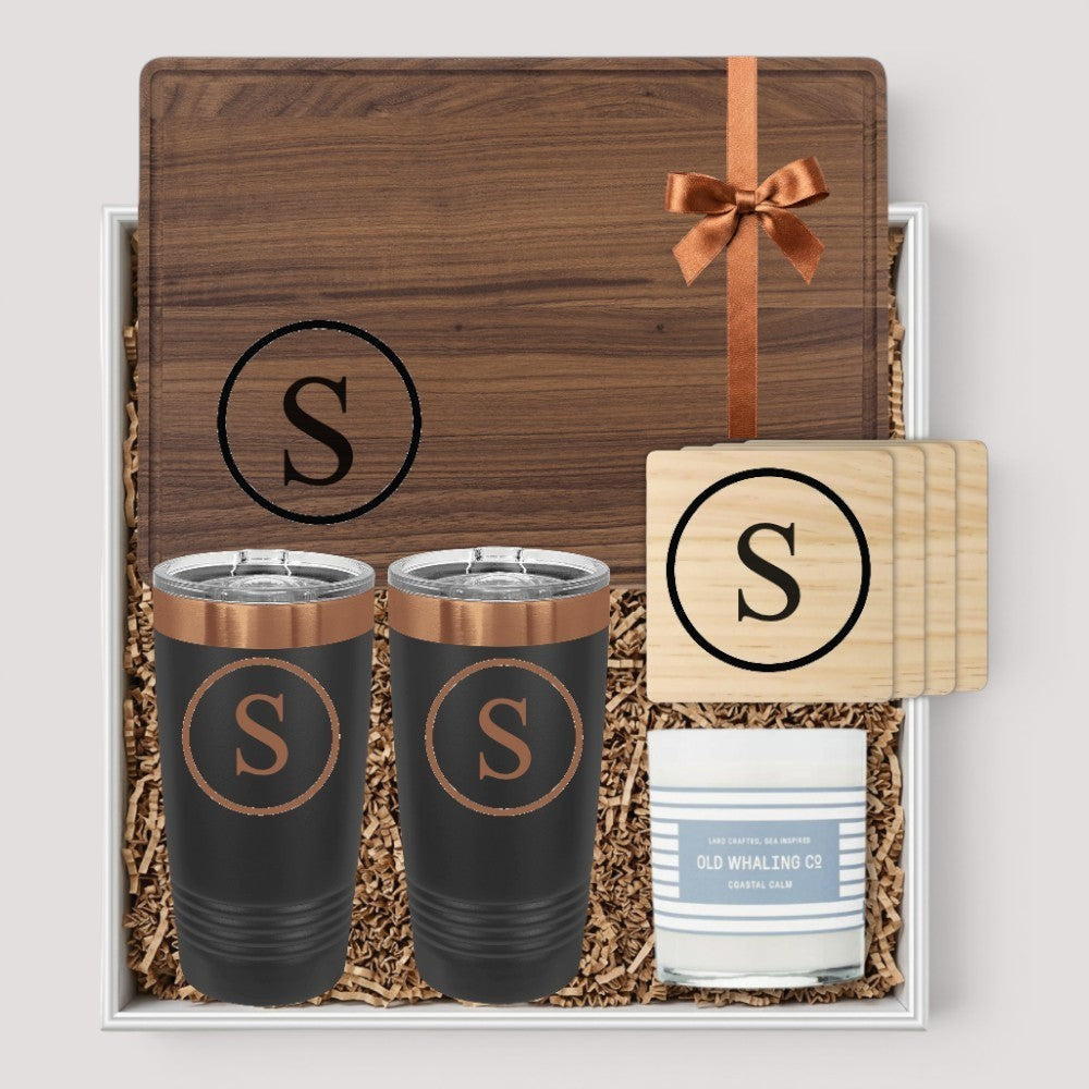 Closing Day Gifts personalized walnut cutting board, two tumblers, marble coasters, and candle in a keepsake gift box.