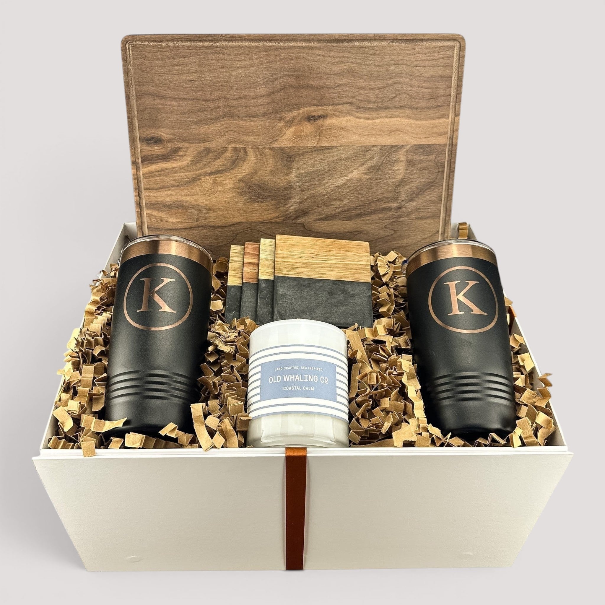 Closing Day Gifts personalized walnut cutting board, engraved tumblers, marble coasters, and candle in a keepsake box.
